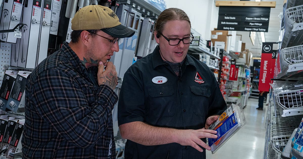 Timberline Ace Hardware's Taylor helping a customer choose metal fittings