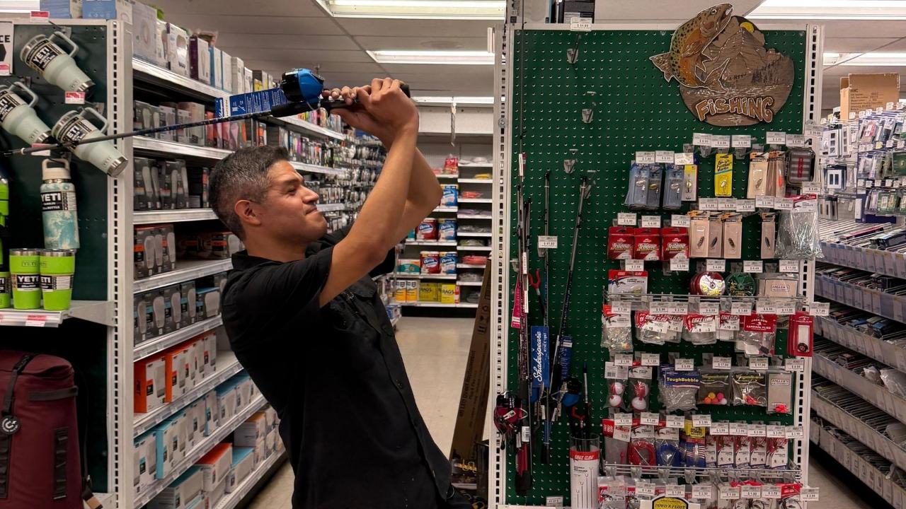 Timberline Ace team member showing a fishing pole in the store's fishing gear section