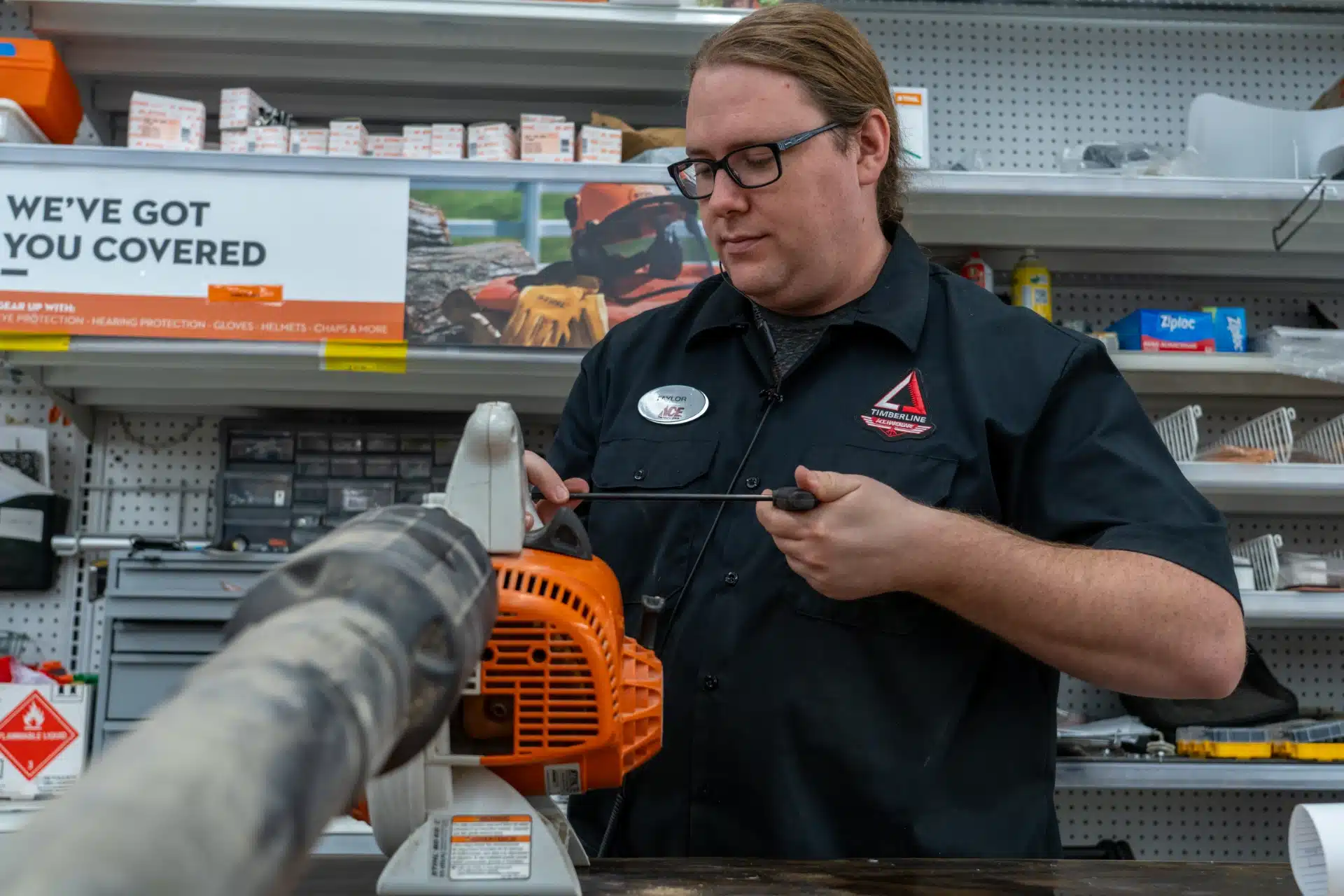 employee at timberline ace fixing a small engine