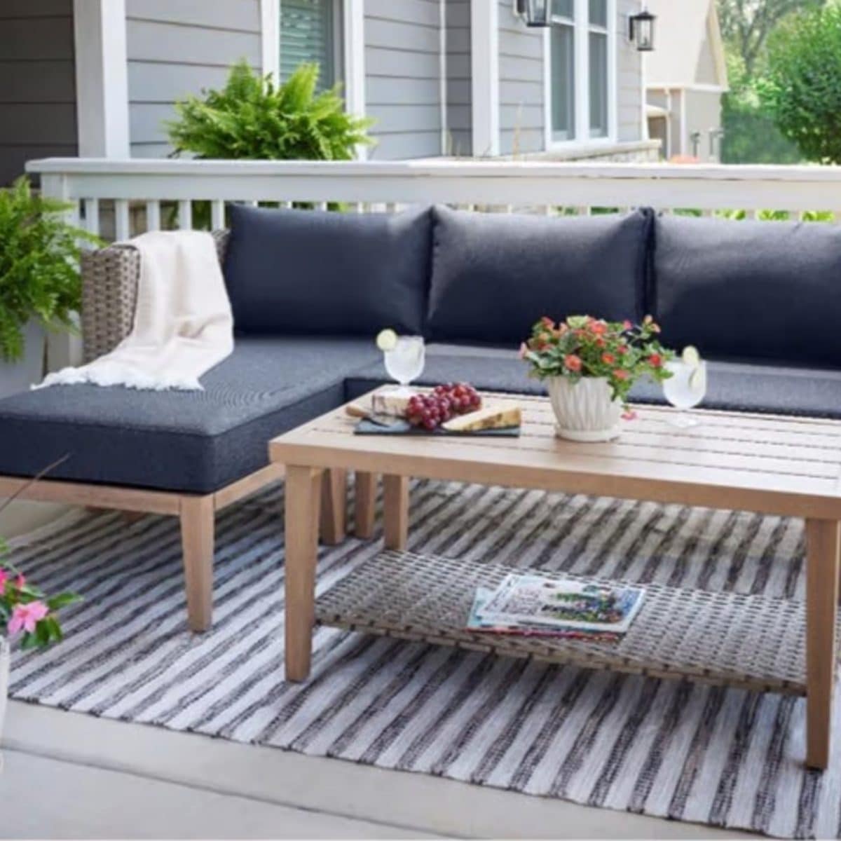 Outdoor sectional patio seating set with cushions and coffee table on deck