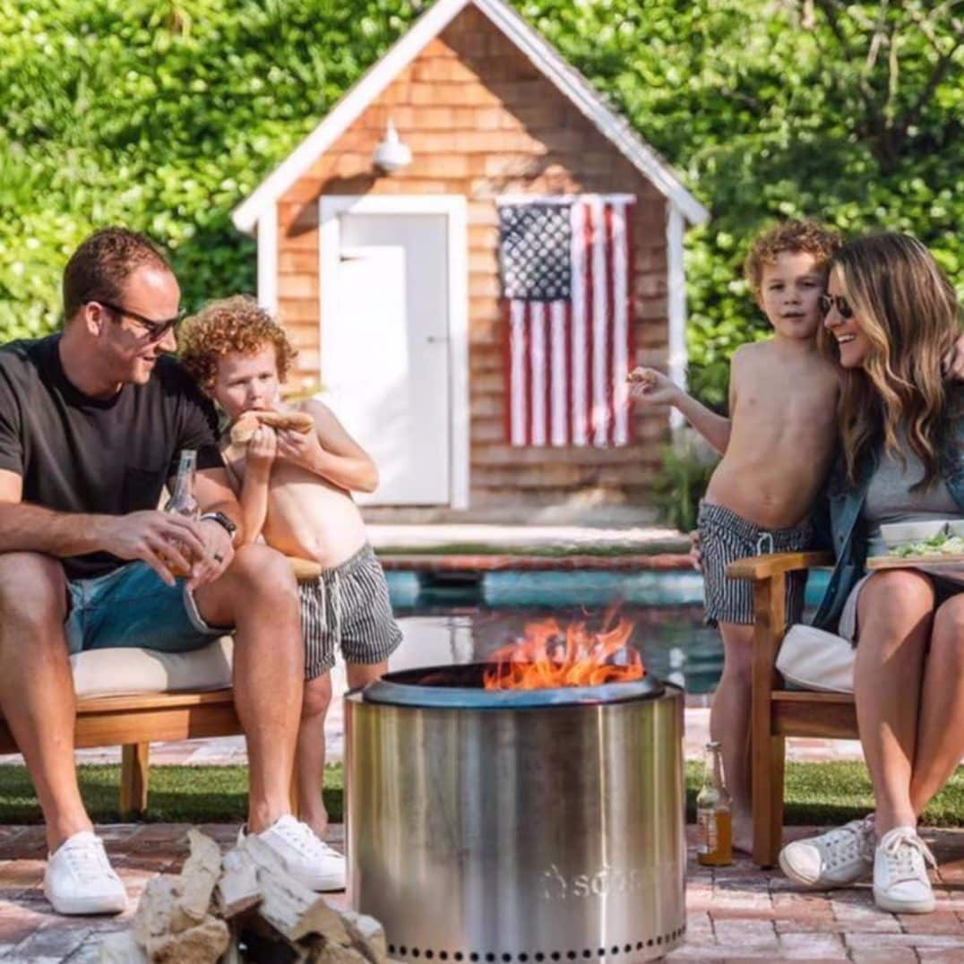 Solo Stove fire pit with family sitting around in backyard